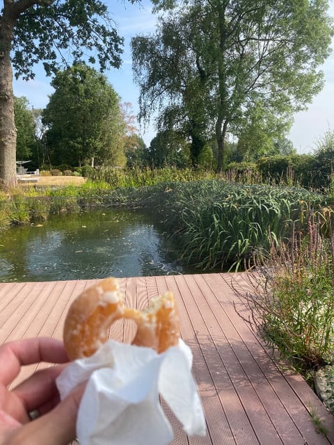 A doughnut from the customer on the decking beside a large pond